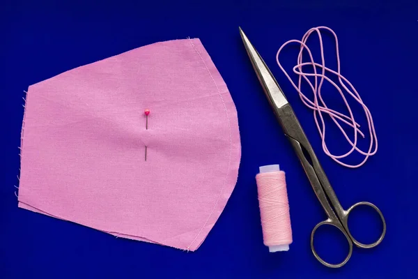 DIY sew handmade how to make cotton fabric face mask against coronavirus disease COVID-19, Do it yourself step by step photo set on blue background. Sewing machine homemade virus medical protection.