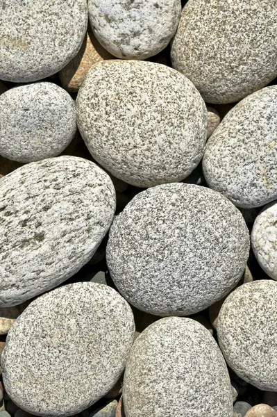 Piedras grandes redondas se apilan una al lado de la otra en un fondo de composición vertical . — Foto de Stock