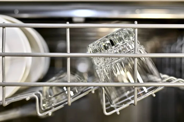 Pure Utensilien funkeln und glänzen auf dem obersten Regal der Spülmaschine, Frontansicht. — Stockfoto