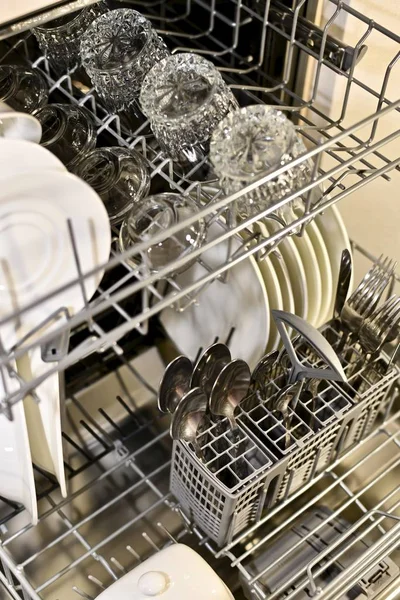 Mencuci piring dalam cahaya hangat dalam keranjang cuci piring diperpanjang di sudut . — Stok Foto