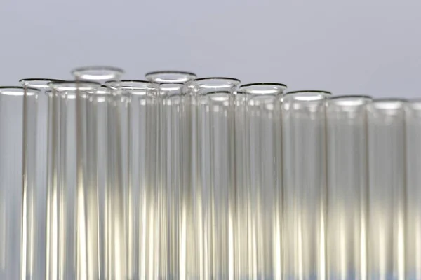 Eine Anzahl transparenter Reagenzgläser der Kehle mit Perspektive sind in Reihen angeordnet. — Stockfoto