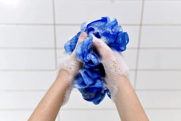 Blauw Plastic Mesh Washandje Met Wit Schuim Handen Van Een — Stockfoto