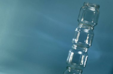 Teneke kutular, mavi arka plana karşı dikey olarak eğimli kuleyle kaplanmış camdan dökülüyor..