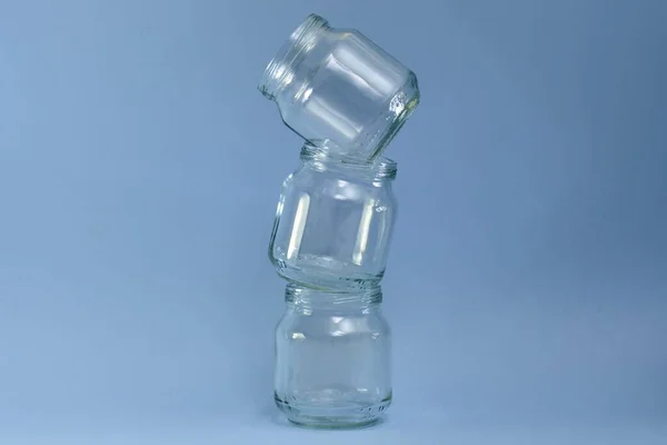 Three cans of glass lined curve tower vertically on a blue background in the center.
