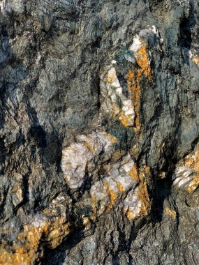 Taşın jeolojik hatası. Yapısal yüzeyin arka planı. Gri mermer ve sarı kahverengi demir korozyonlu pürüzlü, siyah kömür..