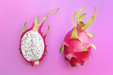 Ejderha meyvesi, olgun pitaya veya egzotik tropikal pitahaya, kaktüs ikiye bölünmüş ve tüm meyve pembe arka planda. Üst Manzara. Yaz, sağlıklı yiyecekler, vegan ya da vejetaryen diyet konsepti.