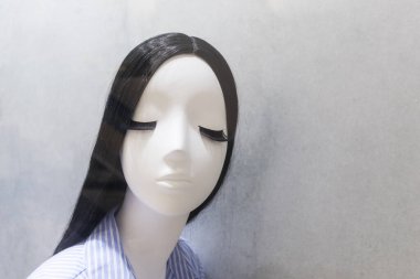 Sahte bir kızın portresi, plastik bir bebek. Mağazada gözleri kapalı ve büyük kirpikleri olan Asyalı mankenler var.