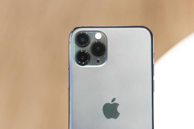 Kuala Lumpur, Malezya - 28.02.20: yeni mor iPhone 11 pro, 11 tane üçlü kamera, gece yarısı yeşil renk. Apple cep telefonu akıllı telefonunun arkası. Fotoğrafı kapat. Modern teknoloji, ahşap kahverengi arka plan bulanık