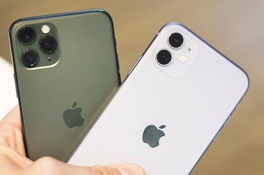 Kuala Lumpur, Malezya - 28.02.20: iki yeni Apple akıllı telefonu: iphone 11 profesyonel gece yarısı yeşili, üç kameralı, iphone 11 çift kameralı mor. Modern cihazlar arasındaki karşılaştırma