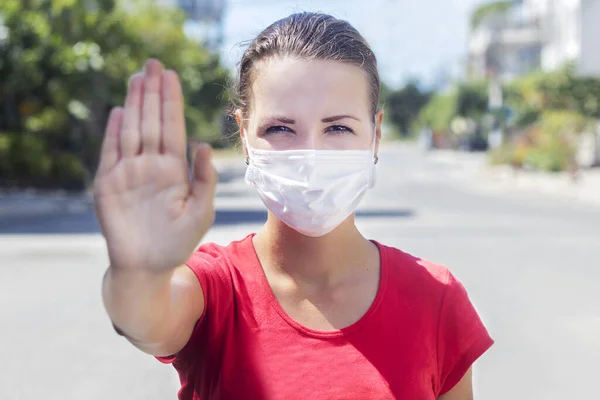 年轻女子戴着无菌防护口罩 面带微笑地看着外面的摄像头 在亚洲街道上展示着手掌 没有停止的迹象 空气污染 中国大流行性大肠癌概念 — 图库照片