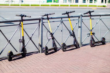 Şehirdeki caddeye elektrikli scooterlar park etmiş. Scooter kiralama, paylaşma