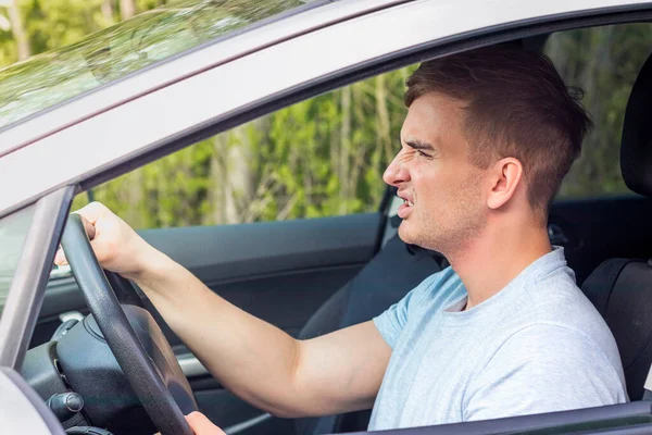 Enojado joven loco agresivo, conductor, frustrado tipo furioso disgustado conducir un coche, problemas en la carretera, atasco de tráfico. Automóvil roto, concepto de agresión. Retrato de hombre trastornado dentro del coche — Foto de Stock