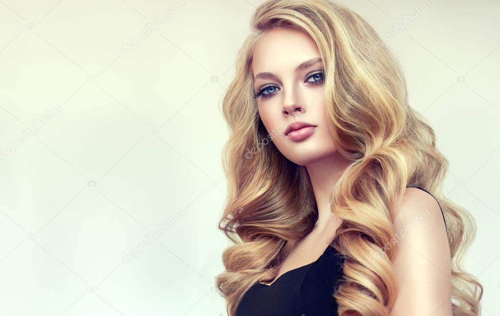 Beautiful model girl with long  curly hair .Red head . Care products ,hair coloring 