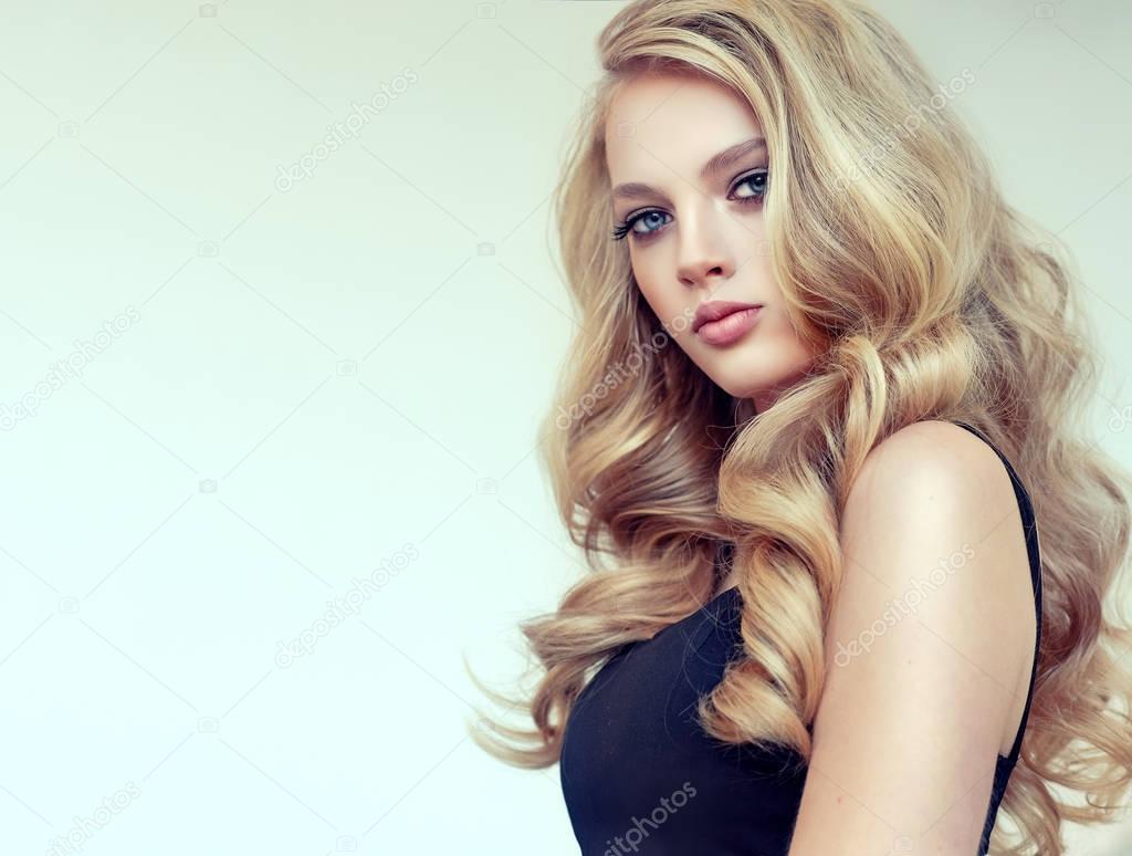 Beautiful model girl with long  curly hair .blond head . Care products ,hair coloring 