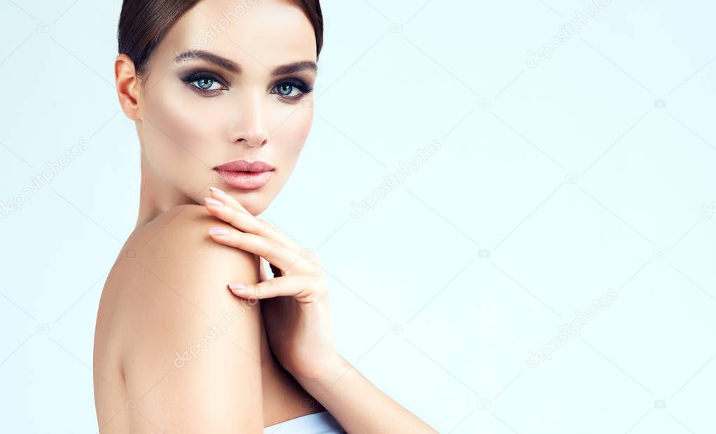Beautiful young woman with clean fresh skin, bare sholders and elegant gesture. Close up portrait. Cosmetic, cosmetology and skin care