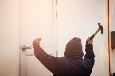 Bir çekiç ile bir evin içine girmeye çalışan hırsız ve 