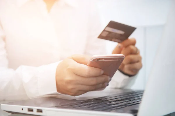 Geschäftsmann benutzt Smartphone und hält Kreditkarte zum Bezahlen — Stockfoto