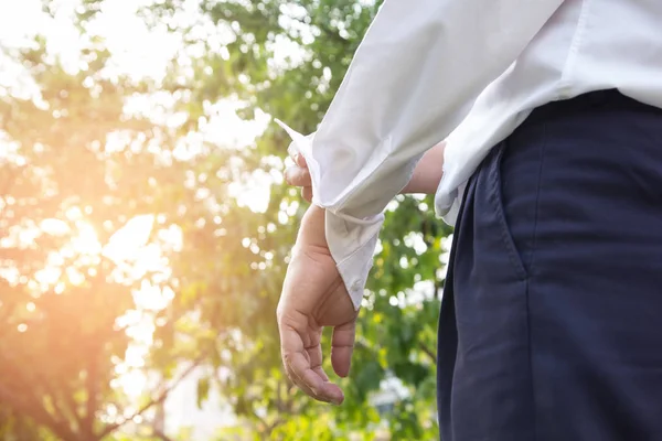 Homem de negócios de terno e uma camisa branca arregaça as mangas em n — Fotografia de Stock