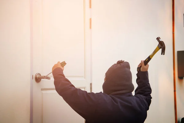 Ladrão tentando invadir uma casa com um martelo e — Fotografia de Stock