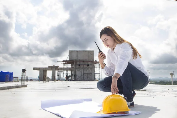 建筑地盘施工现场经理监测生产连续性。建设妇女工作与无线电. — 图库照片
