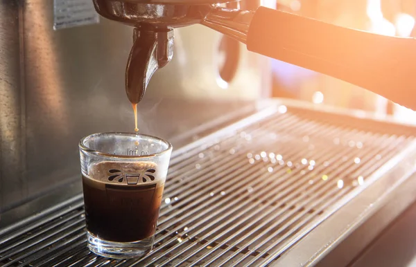 Tasse Espresso mit Kaffeemaschine vorhanden. Kaffeebrühen im Café. — Stockfoto