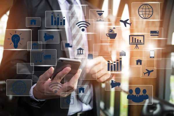 Big data analytics and business intelligence (BI) concept. Businessman hold smart phone and Pressing Virtual icons on a digital screen interface background. Technology 4.0.