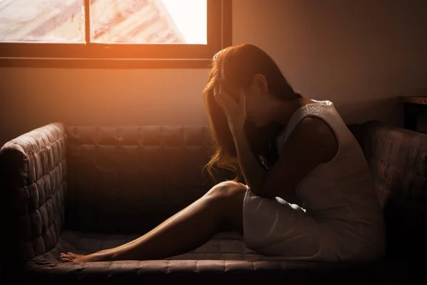 Teenager girl with depression sitting alone in the dark room. major depressive disorder.