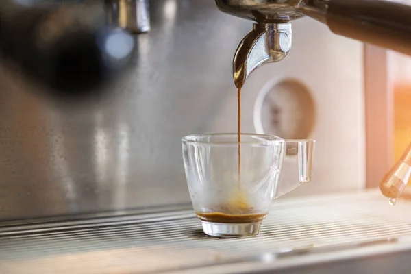 Close-up of espresso pouring to cup from coffee machine. Small b — Stock Photo, Image