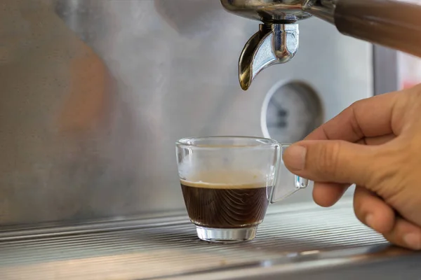 Close-up of espresso pouring to cup from coffee machine. Small b — Stock Photo, Image