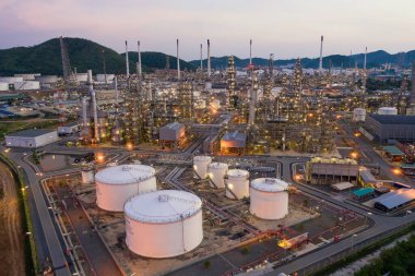 Petrol rafineri fabrikası endüstrisi ile petrol depolama tankının hava görüntüsü. Güneş batımında ve alacakaranlıkta petrol rafinerisi. sanayi fabrikası kavramı ve taşımacılığı.