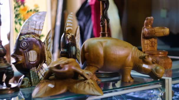 Souvenirs orientales en la tienda, hipopótamos de madera, tortugas, peces — Vídeos de Stock