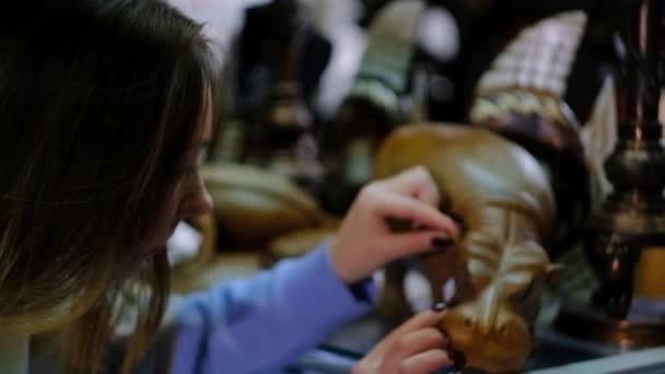 Jong meisje kiest een souvenir in de winkel — Stockvideo