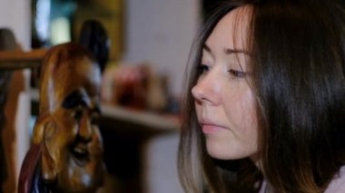 Genç kız dükkanda bir hatıra seçiyor.