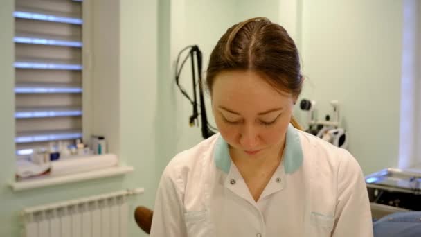 The nurse is chewing on a hair cap — Stock Video