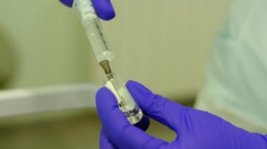 nurse draws medicine into syringe