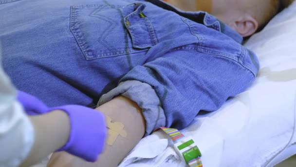 Um homem de fato de ganga recebe uma perfusão intravenosa — Vídeo de Stock