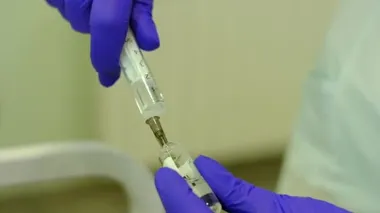 nurse draws medicine into syringe
