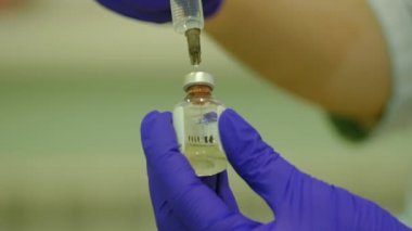 nurse prepares medicine against coronavirus in vial