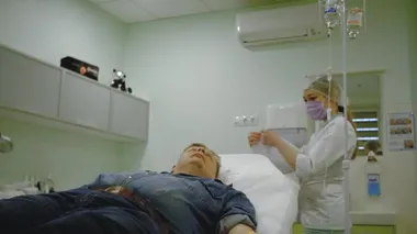 nurse puts paper crown on patient