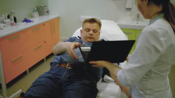 Paziente maschio che parla su un computer portatile durante un contagocce — Video Stock