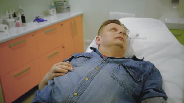 Медсестра надевает коронавирусную корону на пациента мужского пола — стоковое видео