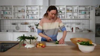 Kız yemek pişirirken telefonda konuşuyor.