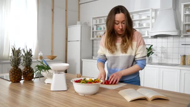 Flicka i köket förbereder enligt receptet — Stockvideo