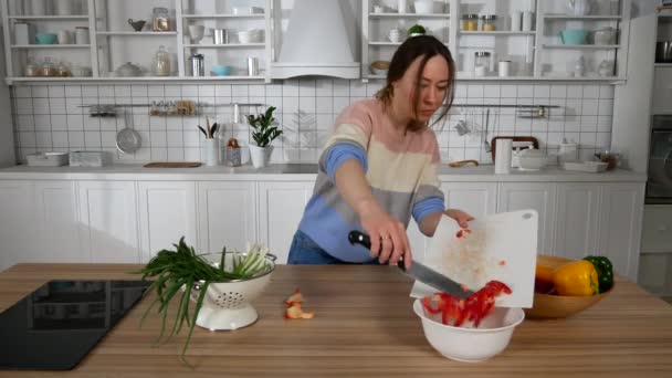 Девушка танцует на кухне и готовится к еде — стоковое видео