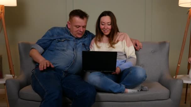Couple talking to someone on video chat on laptop — Stock Video