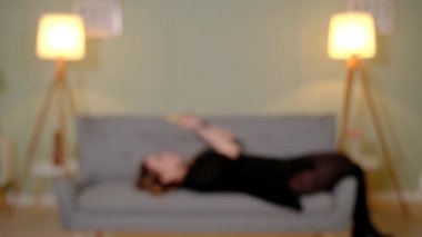 Kanepedeki kız mobil oyun oynuyor.