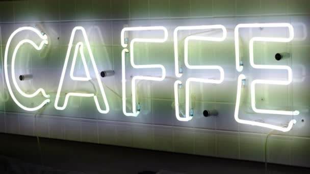 Neon luminous inscription caffe filmed on video with hand — Stock Video