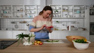 Kız cep telefonuyla konuşuyor ve yemek hazırlıyor.