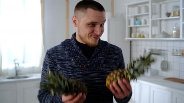 Mann in der Küche hält Ananas in der Hand — Stockvideo