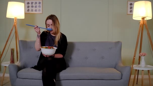 Paar eten salade op de bank — Stockvideo